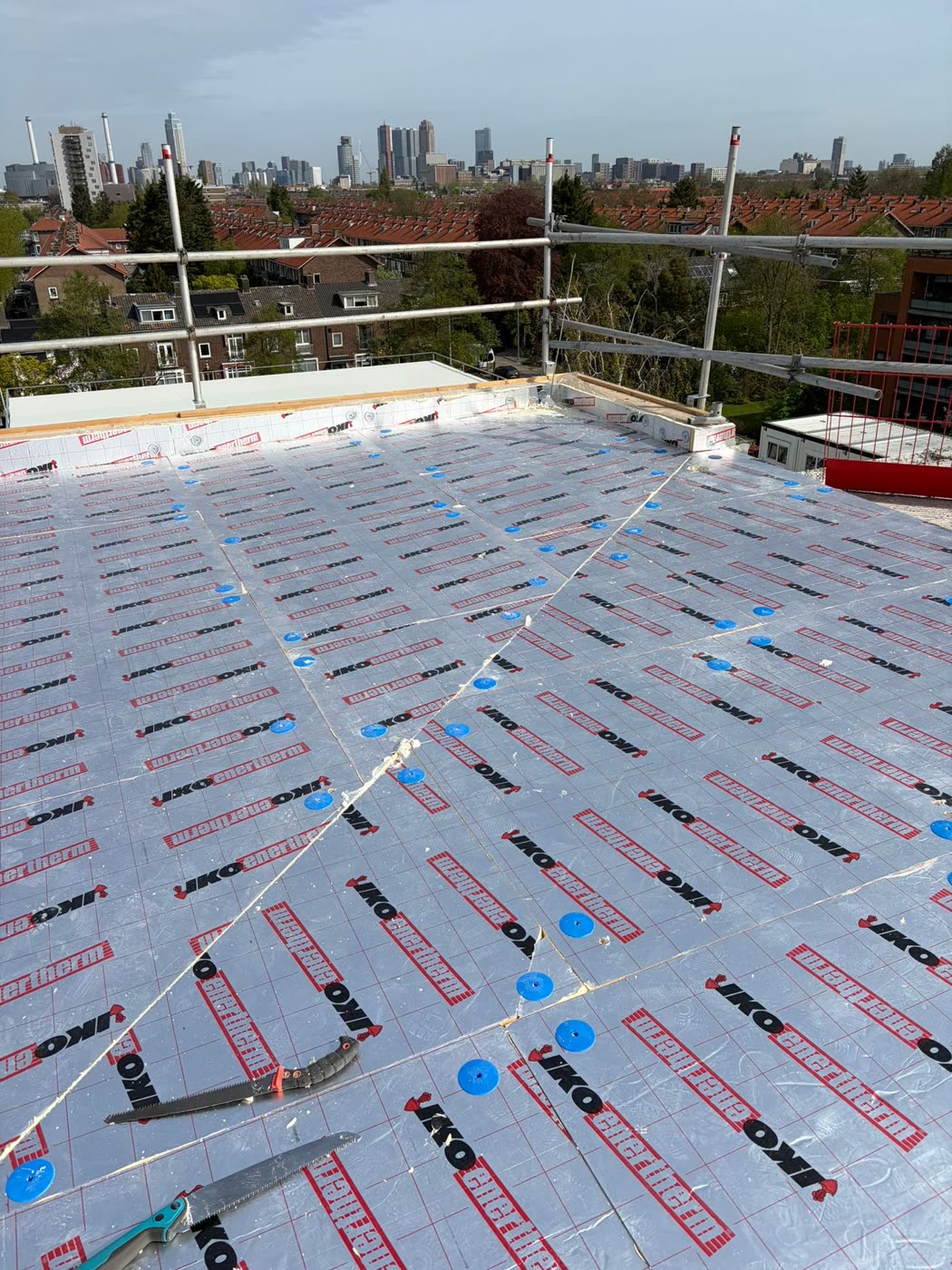Plat dak met nieuwe isolatieplaten, met de skyline van Rotterdam op de achtergrond